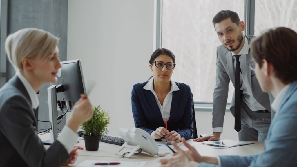 Business team reviewing a policy document together in a modern office, representing AI governance policy planning