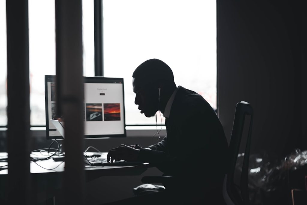 Employee working on a laptop at a desk, representing unmonitored or shadow AI tool usage in the workplace